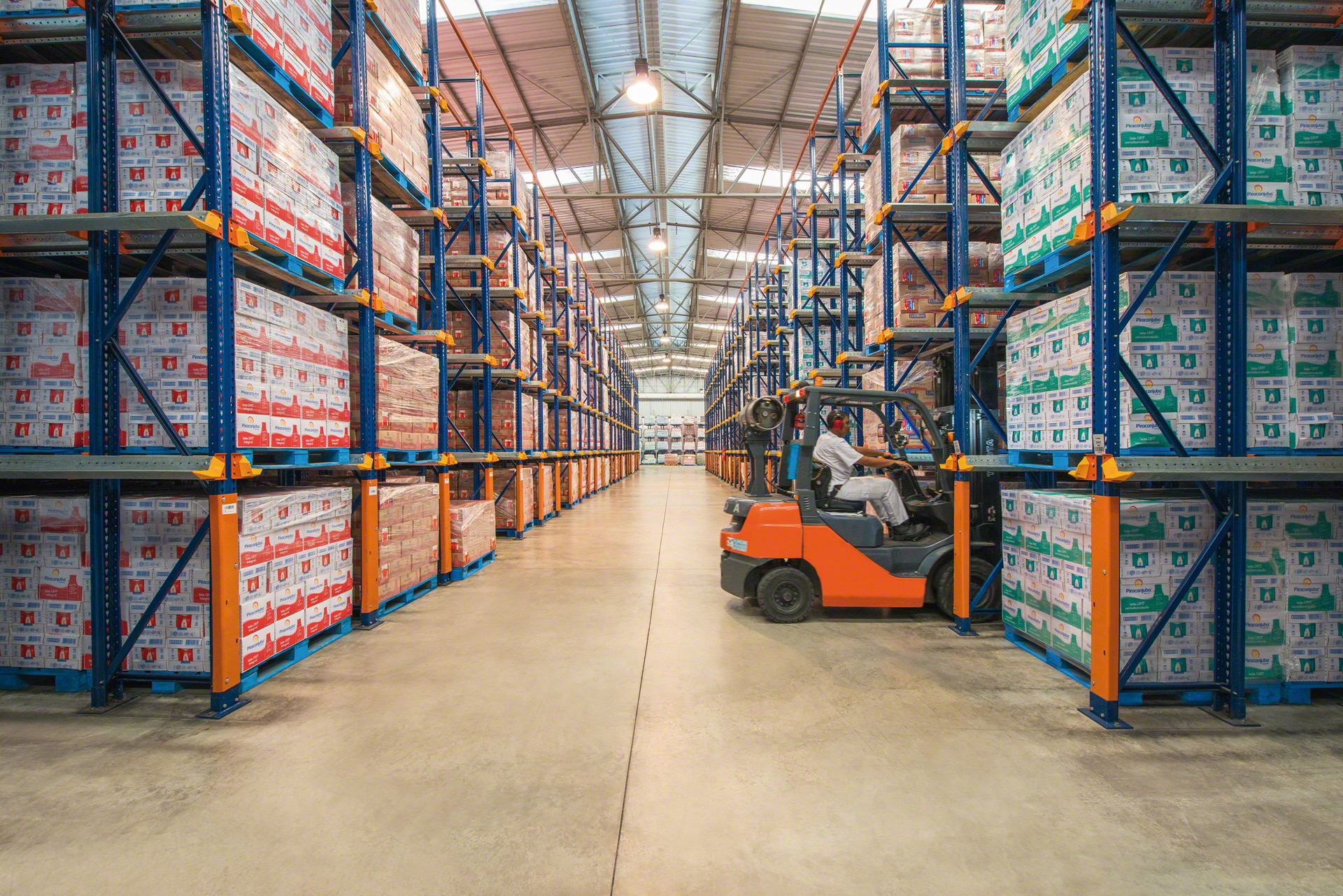 Forklift trucks run inside the drive-in storage lanes